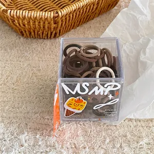Close-up of seamless hair ties in coffee tones inside a cute cartoon storage box