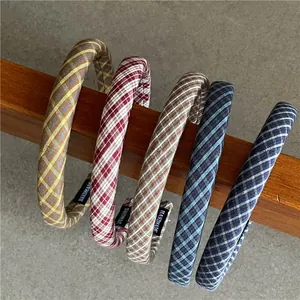 Detail of classic plaid fabric headbands in various colors hanging on a wooden rod