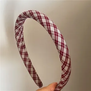 Close-up of sponge padded headband with red and white argyle pattern fabric texture