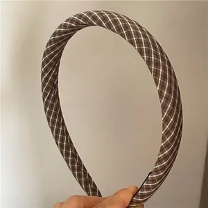 Detail shot of brown and white checkered fabric headband with vintage college style