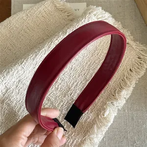 Detail of burgundy PU leather headband with fine stitching and protective black ends
