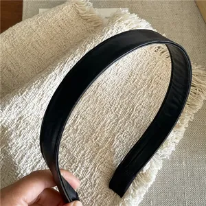 Detail view of the stitching on a minimalist black faux leather headband with anti-slip tips