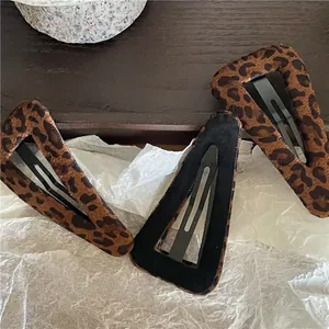 Détail de trois barrettes BB triangulaires à motif léopard avec texture en velours