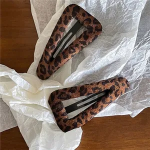 Deux pinces à cheveux rétro à motif léopard géométrique sur fond texturé