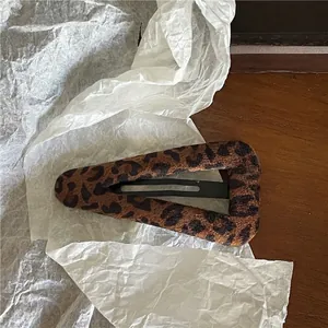 Vue détaillée de la pince à cheveux triangulaire léopard avec une finition velours