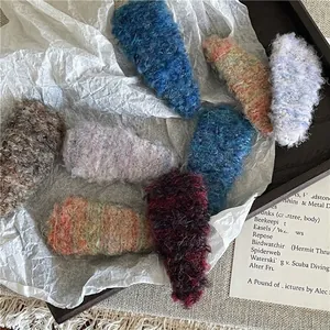 Colorful plush waterdrop hair clips on a white artistic paper and wooden tray