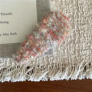 Macro detail of mixed color plush snap hair clip showing soft knitted fabric texture