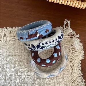 Détail de quatre chouchous en maille à motifs sur un tapis tissé et table en bois
