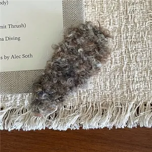 Close-up of the textured brown-grey curly plush fabric on a classic teardrop BB hair clip