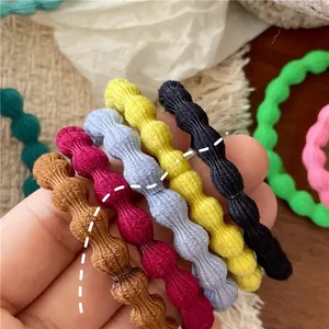 Close-up of colorful ribbed fabric scrunchies in various shades on a textured background