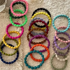 Set of pastel wave textured high elasticity hair ties in multiple colors on beige fabric