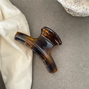 Detail shot of a large translucent amber claw clip on a textured stone surface