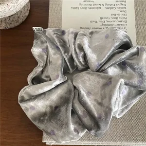 Detailed view of silver grey velvet scrunchie with purple polka dots and soft folds