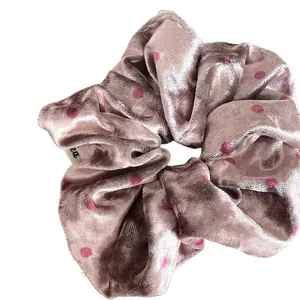 Pink velvet scrunchie with dark pink polka dots design on a clean white background