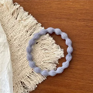 Close-up of elastic light purple hair tie with soft wavy texture on wooden surface