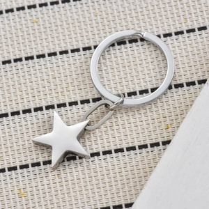 Polished silver 3D star keychain made of durable stainless steel on a textured background