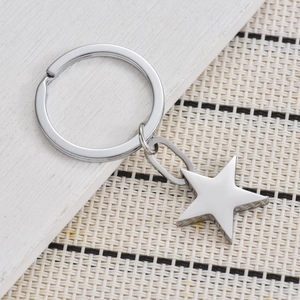 Polished stainless steel star keychain with a silver finish on a rustic wood background