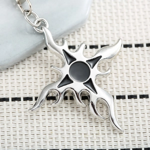 Hip hop style flame cross keychain in silver and black metal on stone prop