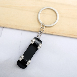 Creative daisy skateboard keychain in black and silver on a minimalist marble background