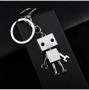 Détail macro du porte-clés robot argenté sur un fond en cuir noir texturé