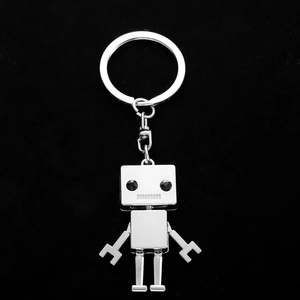 Sleek silver metal robot keychain with rhinestone eyes on black velvet background