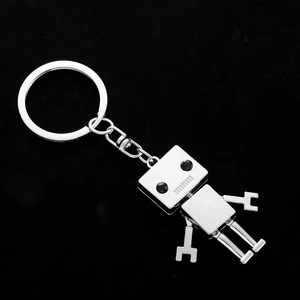 Creative silver metal robot keychain with black eyes on a dark background for car keys