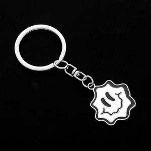 Porte-clés smiley ondulé avec fermoir mousqueton argenté sur un fond noir uni