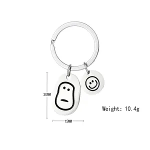 Detail view of smiley face stainless steel charms on a keychain weighing 10.4g