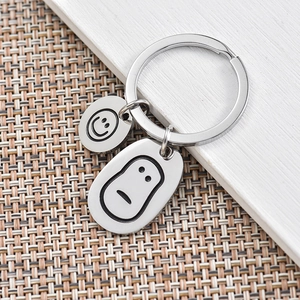 Polished stainless steel keychain featuring cute smiley and sad face charms on a ring