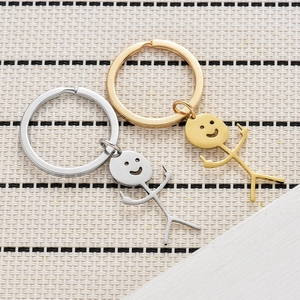 Detailed top view of polished gold and silver funny middle finger doodle keychains