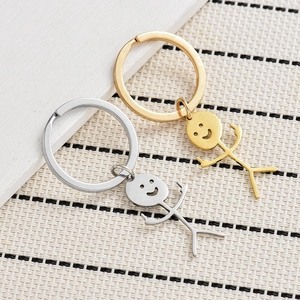Detailed view of silver and gold stainless steel stickman middle finger keychains