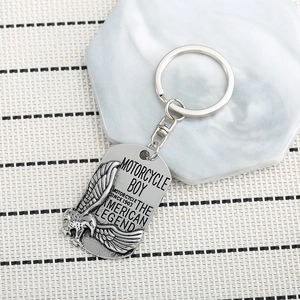 Vintage eagle wings motorcycle boy metal keychain with silver finish on marble background