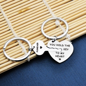 Detailed macro shot of stainless steel key and heart couple keychains with forever engraving