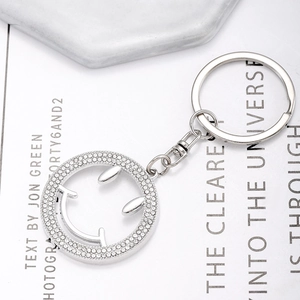 Porte-clés visage souriant évidé avec strass brillants sur fond de style moderne