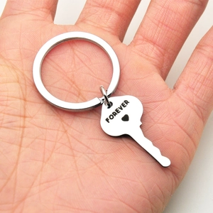 Polished stainless steel key keychain with Forever engraving held in hand for size comparison