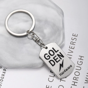 Silver metal rectangular keychain with lightning logo on grey marble stone background