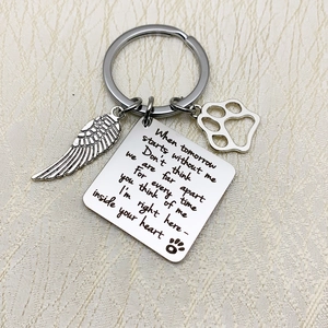 Detail of pet memorial keychain with feather wing charm and engraved poem plate