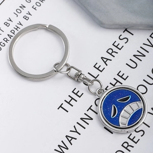 Rotating metal keychain featuring a blue glittery anime face pendant for backpacks