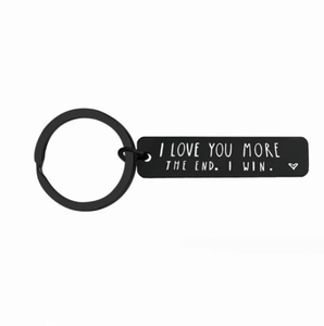 Porte-clés noir en acier inoxydable avec gravure I Love You More sur fond blanc