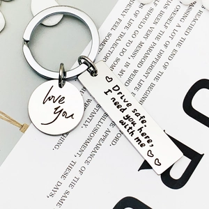 Stainless steel keychain with Drive Safe engraving and Love You charm on modern background