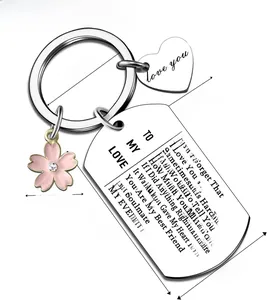 Close-up of stainless steel keychain with pink flower and engraved love message pendant