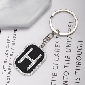 Close-up of hip hop style metal keychain with rhinestone letter H charm on magazine