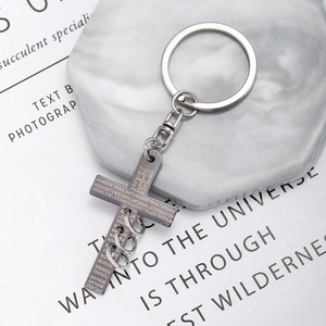 Macro shot of silver stainless steel cross keychain with engraved Spanish prayer text