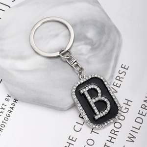 Close-up of hip-hop style rectangular keychain with sparkling rhinestones and letter B