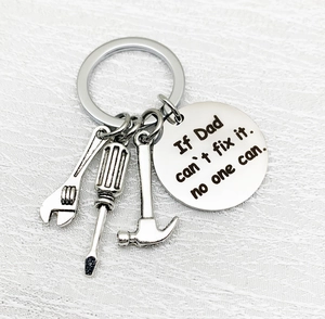 Detail of silver tool keychain with Dad engraved tag and miniature hammer screwdriver wrench