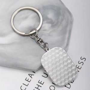 Hip-hop silver square pendant keychain with textured back on marble background