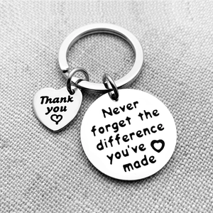 Detail of engraved stainless steel retirement keychain with inspirational quotes on linen