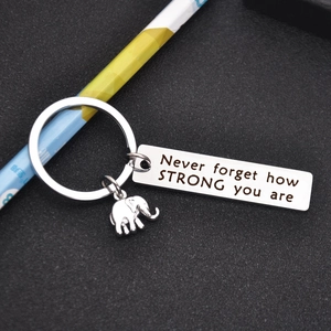 Close-up of stainless steel elephant keychain with engraved motivational quote