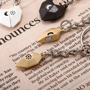 Magnetic heart couple keychains with sun and moon symbols on vintage newspaper