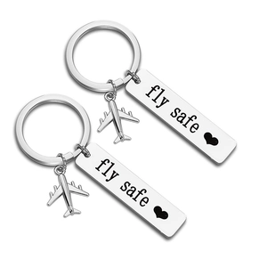 Detailed macro view of polished stainless steel Fly Safe keychain with airplane charm